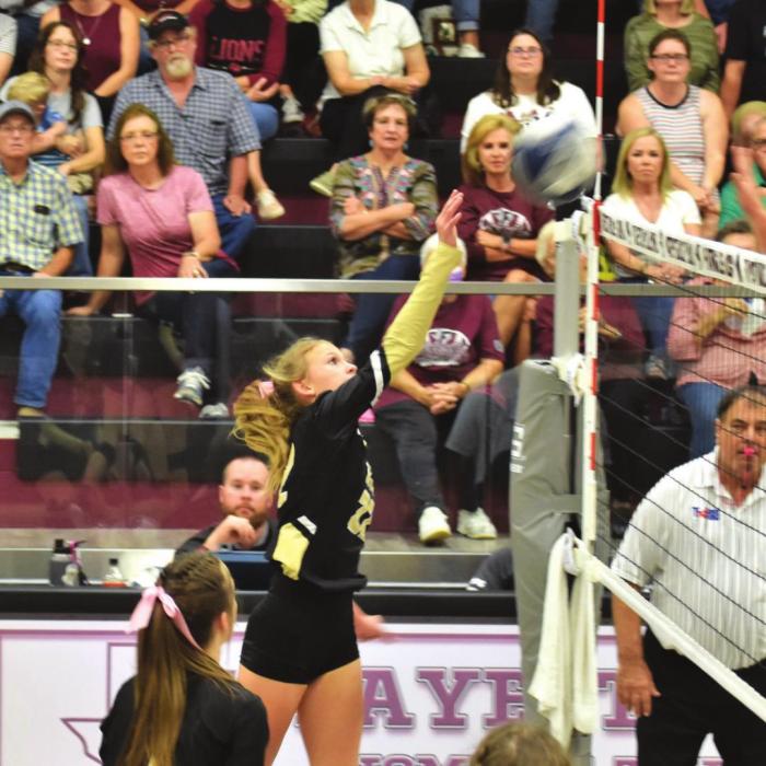 Fayetteville fans look on as Round Top-Carmine’s Tess Eilers spikes a ball in Friday’s match. Photo by Paul Kipp
