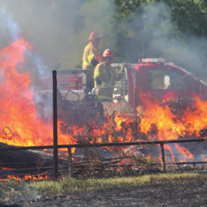 After putting out one portion of the fire, La Grange volunteer firefighters drive to a new part of what was a 1.5-acre fire off Plum Church Road Wednesday. Photo by Jeff Wick