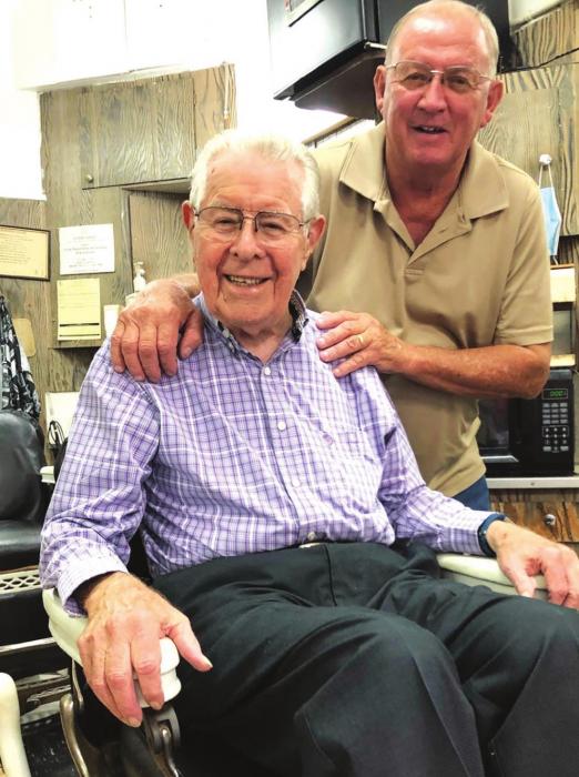 When Ken moved to his new barbershop, he relocated his two 106-year-old antique barber chairs and the mirrors behind them. The chairs, which were manufactured by Emil Paidar Co. of Chicago in the early 1900s, have stood the test of time as both Ken (standing) and Charlie (seated) attested. (Elaine Thomas shot this photo several weeks before the state and citywide masking order.)