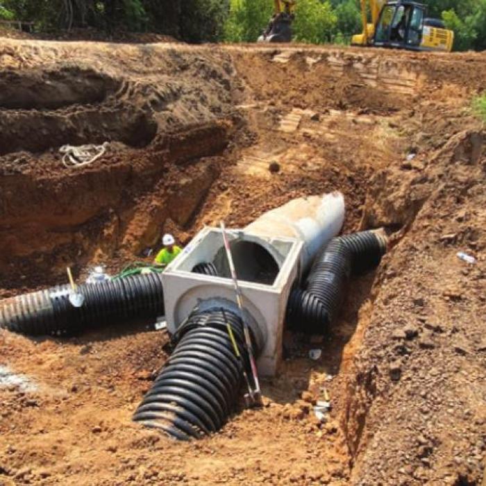 School drainage piping junction box north of river discharge headwell.