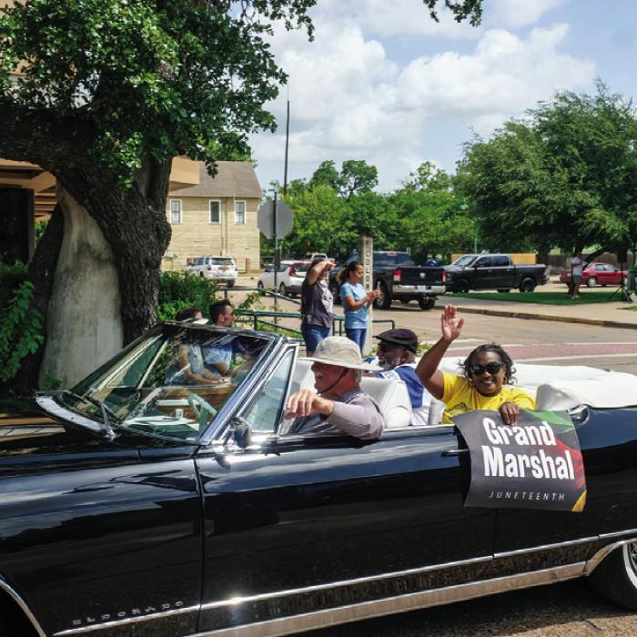 The parade grand marshal, Rev. Andrew Stafford of Schulenburg (seated back, left), rode in a classic black Cadillac El Dorado.