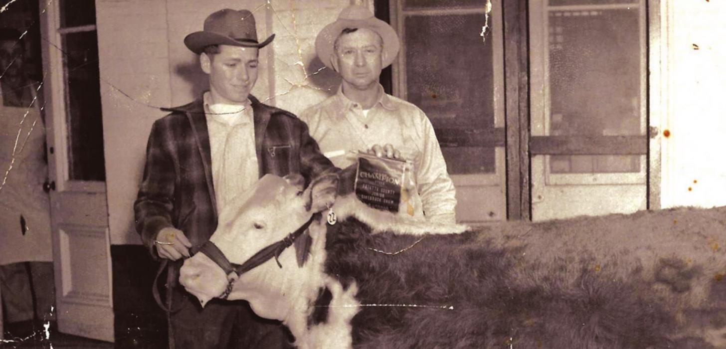 Glen Prause Sr. is shown here standing in front of Prause Market with a grand champion show calf held by Morris Zapalac. Jimmy Prause, Glen’s brother, is standing in the far left of the photo in the doorway of the meat market. This picture was taken in 1940’s. They are the second generation of Prauses to run the market after it had moved to the east side of the courthouse square.