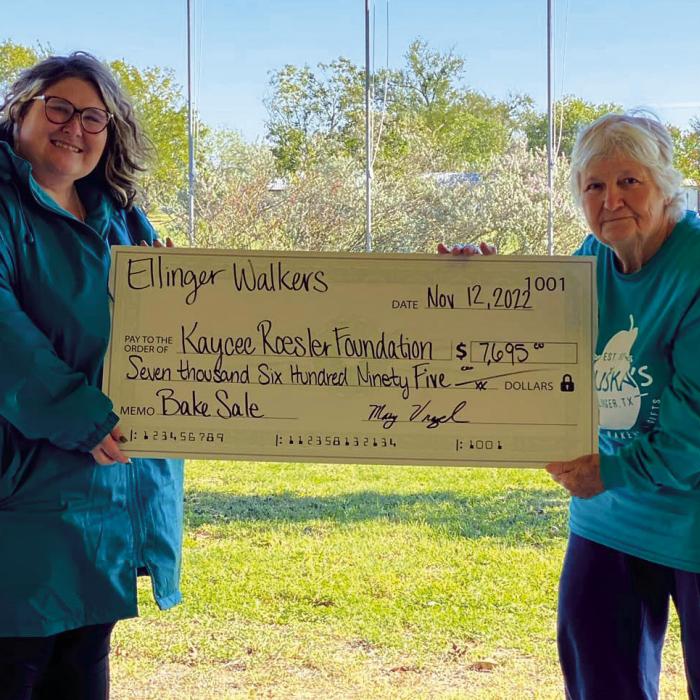 The Ellinger Walkers represented by Mary Vrazel (right) presented Kaycee Roesler (left) of the Kaycee Roesler Foundation a donation in the amount of $7,695. Funds were raised from a bake sale held by the Ellinger Walkers in April and on Saturday, November 12. A portion of the proceeds will go to a local scholarship and the remainder will be used to help pay for medical expenses. Kaycee was diagnosed with Multiple Myeloma, a rare blood cancer within the plasma cells.