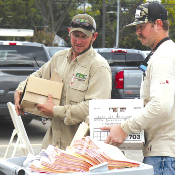 FEC Lineman Corey Brown and lineman apprentice Justin Neiser prepare documents for shredding at last year’s Community Shred Day.