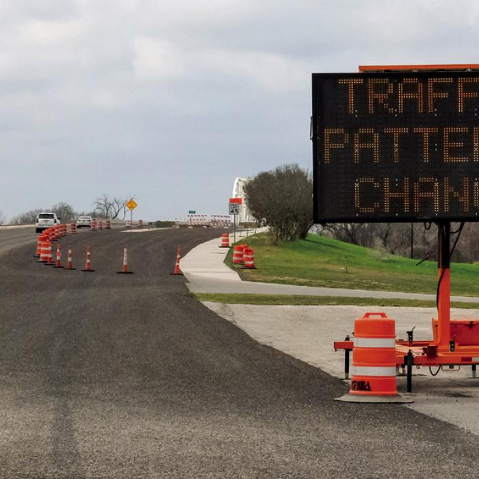 A sign on Business 71 (Travis St.) advises motorist of the upcoming traffic pattern changes on Feb. 23. The old river bridge will reopen on that day after more than two years for repairs and rehabilitation. When it opens, the old bridge will carry westbound traffic in a single lane while eastbound traffic will remain on the new concrete bridge, also in a single lane. Photo by Andy Behlen