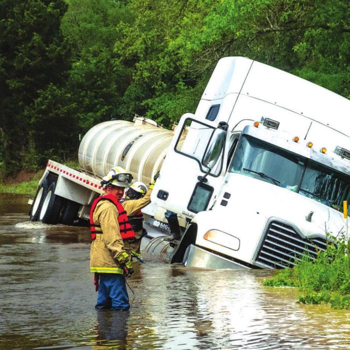 Ledbetter firefighters get ready to rescue local truck driver Tomas Garza after his rig washed off Goehring Road at Cummins Creek in May.