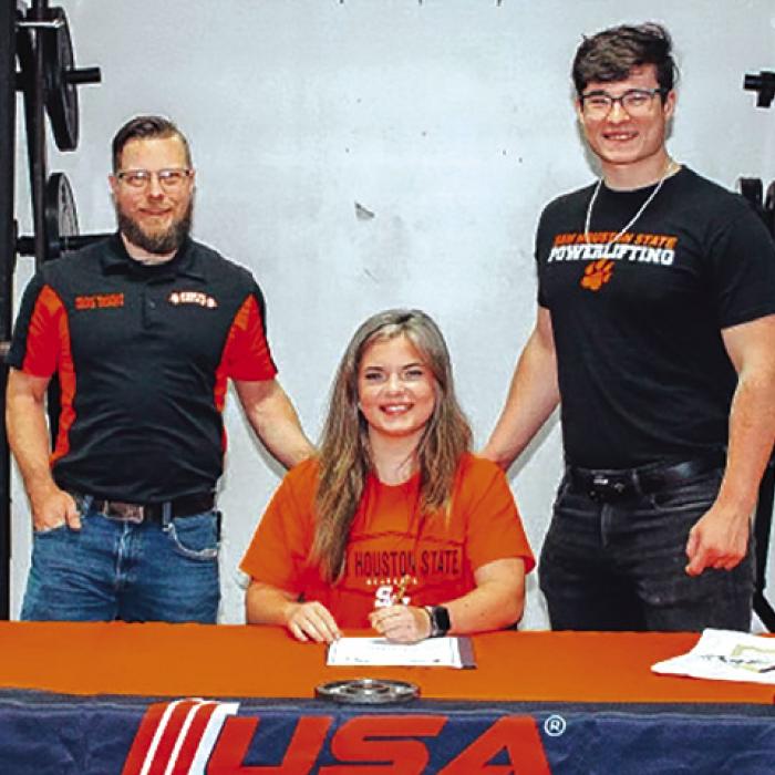 La Grange Senior Powerlifter Danyelle McIntyre, a 6th place State finisher, signed a letter of intent to join the Sam Houston State University Powerlifting team last week. She is shown, center, at her signing ceremony. Left is SHSU powerlifting coach Michael Hafenbrack, and right is Danyelle’s brother Hadyn McIntyre, himself an SHSU powerlifter.