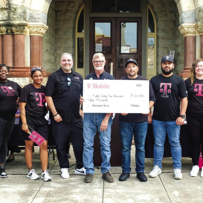 T-Mobile presented the Fayette County Fair Association with a $50,000 Hometown Grant on Thursday, July 17, in a ceremony in front of the Courthouse. Pictured hold the check in the center are Fair Association President Michael Zuhn (left) and T-Mobile Market Manager Rick Molina (right), along with a delegation of representatives from T-Mobile. Photo by Andy Behlen
