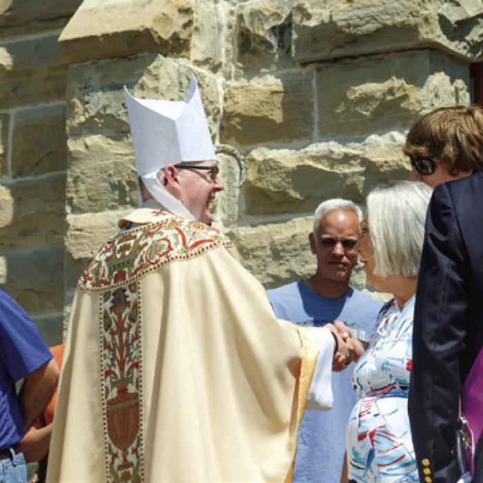 Bishop Brendan Cahill greets the faithful after mass in Praha on Tuesday.