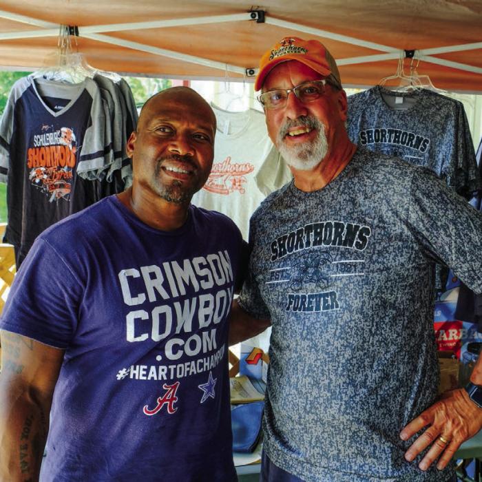 Former Dallas Cowboy Sherman Williams (left) was at the Festival signing autographs as part of a fundraiser for the Boys and Girls Club. He is pictured here with Mike “Bubba” Olle at the Shorthorns Forever booth on Saturday.