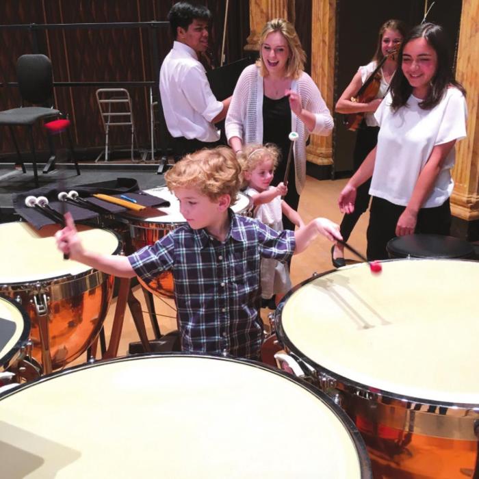 Festival Hill orchestra members encourage a future timpanist during annual Young Persons Concert.