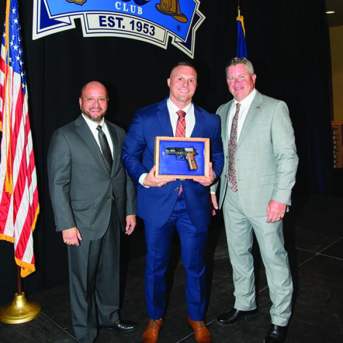 100 Club President Ray Garcia (left) and Executive Director William Skeen (right) presented La Grange Police Officer Mitchell Maxwell with an Officer of the Year award at the 100 Club’s annual banquet on May 22. Maxwell (center) is pictured with a commemorative pistol that came with the award.