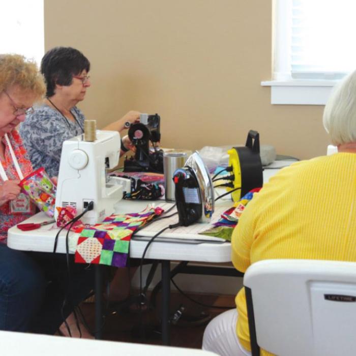 Above and below: Colorado Valley Quilt Guild members at work creating quilts to be donated to local nursing homes.