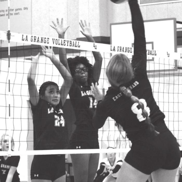 La Grange’s CiCi Barcenas and Tori Harold jump to try to block this hit by East Bernard’s Lexie Warncke Tuesday.