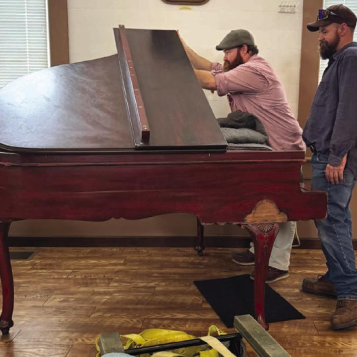 Marquis and Quinton Burkham (brothers) from Plum Piano Restoration in La Grange delivered the piano and will tune and restore it the piano.
