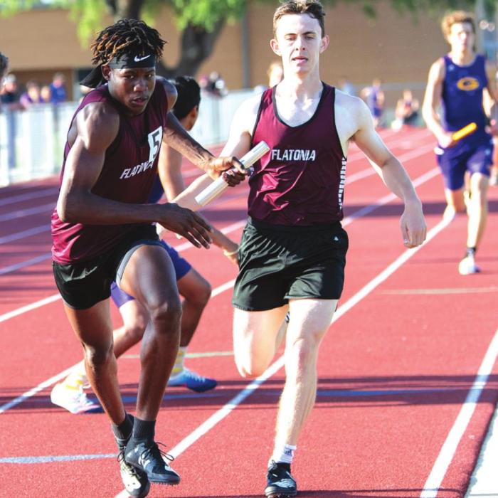 Third leg runner Luke Law hands off to 4th leg of mile relay Jaidyn Guyton. The Flatonia Bulldog mile relay team won first place and is advancing to Regionals. Photo by Stephanie Steinhauser