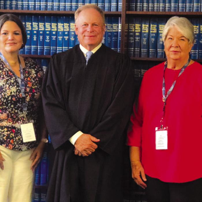 Tiffany Miller (left) and Nancy Walters (right), both residents of Elgin in Bastrop County, were sworn in by Judge Benton Eskew (center) as new CASA volunteers.