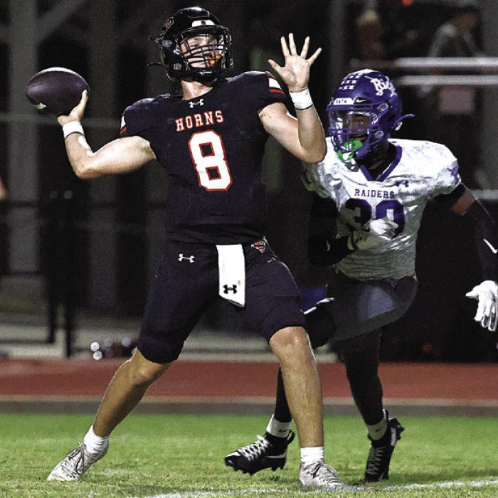 Schulenburg quarterback Owen Brenek prepares to pass as a Rice player bears down on him. Photo by Darrell D. Gest