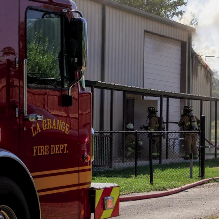 La Grange volunteer firefighters prepare the enter the burning pottery workshop at Gray Legacy Services on Monday, July 20. Photo by Andy Behlen