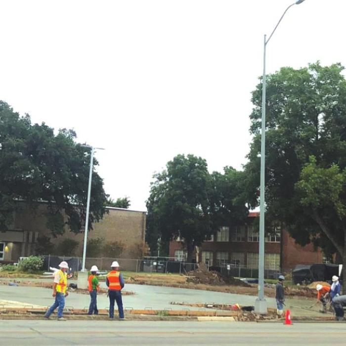 This crew was pouring concrete via a Gateway Arch of sorts Tuesday morning in a parking lot at the La Grange school campus along Travis Street. Photo by Regina Keilers