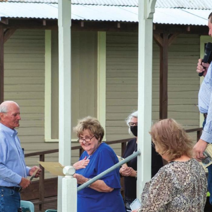 TCHCC President Retta Chandler (center) reacts after Mark Hermes (right) made a surprise announcement that one of the trees would be dedicated in her honor.