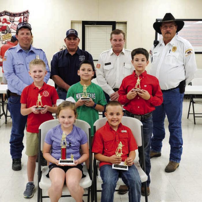 Winners in the Intermediate Division (Grades 3 and 4) went to (front, from left) First Place - JoLee Kuehn, Second Place - Hunter Wagner, Third Place - (not pictured) Brody Brossmann, (middle row) Honorable Mention - Blake Markwardt, Christopher Estrada and Micah Garcia. Also pictured are (back row) Fayette County Firefighters Andrew Baker of Muldoon VFD, Quentin Riche of Schulenburg VFD, Calvin Krause of Round Top-Warrenton VFD and Keith Burcalow of Round Top-Warrenton VFD.