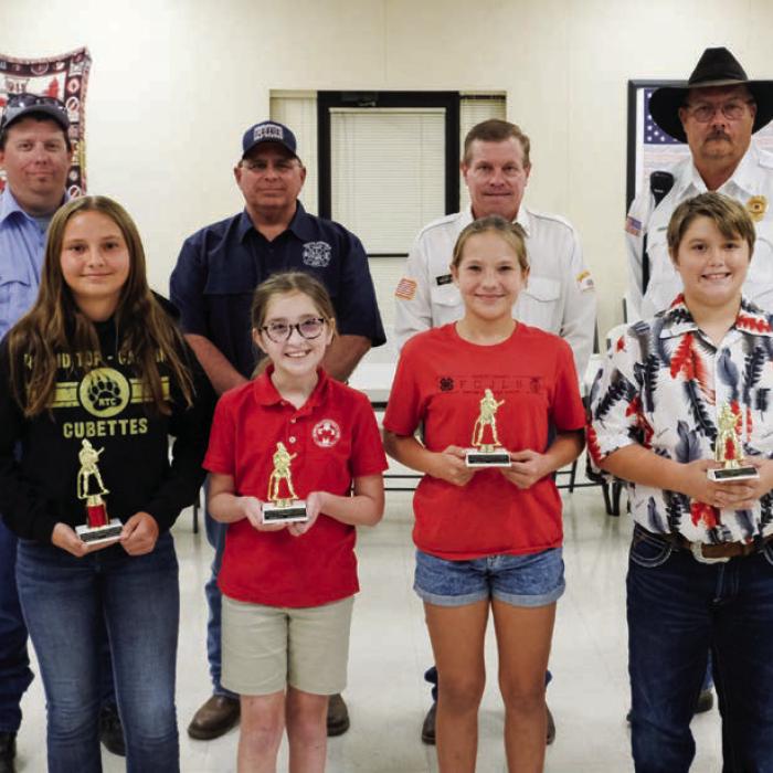 Winners in the Middle Division (Grades 5 and 6) went to (front, from left) Third Place - Daisy Visser, Honorable Mention - Kacie Nichols, Lilly Herzog and Noah Heger. Not pictured were First Place - Brielle Goedrich and Second Place - Olivia Otto. Also pictured are (back row) Fayette County Firefighters Andrew Baker of Muldoon VFD, Quentin Riche of Schulenburg VFD, Calvin Krause of Round Top-Warrenton VFD and Keith Burcalow of Round Top-Warrenton VFD.