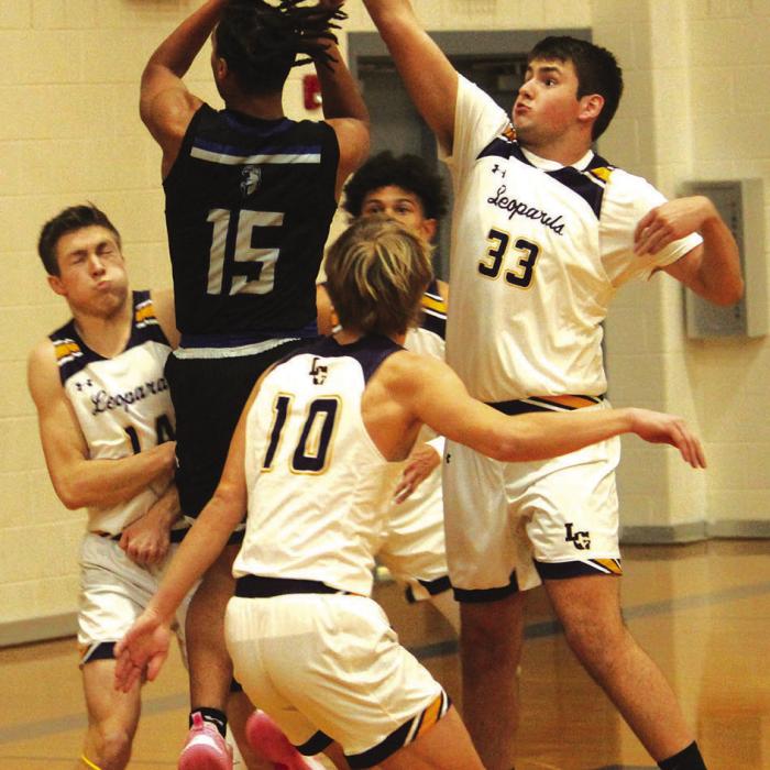 La Grange’s Clayton Knapik, left, takes a charge as teammate Reece Nygren, right, blocks a Manor shot Friday. Photo by Jeff Wick