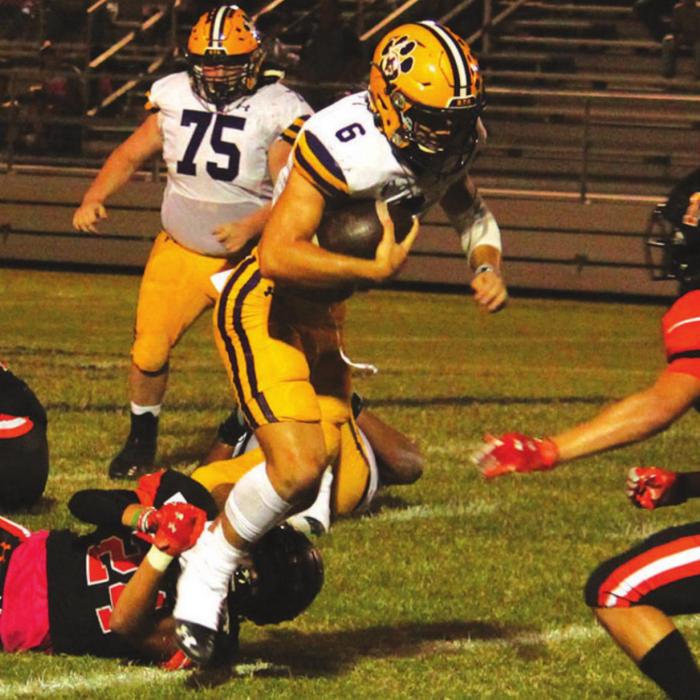 La Grange quarterback Clay Wolff drags along one Gonzales tackler as he prepares for a hit from another Friday. Photo by Jeff Wick