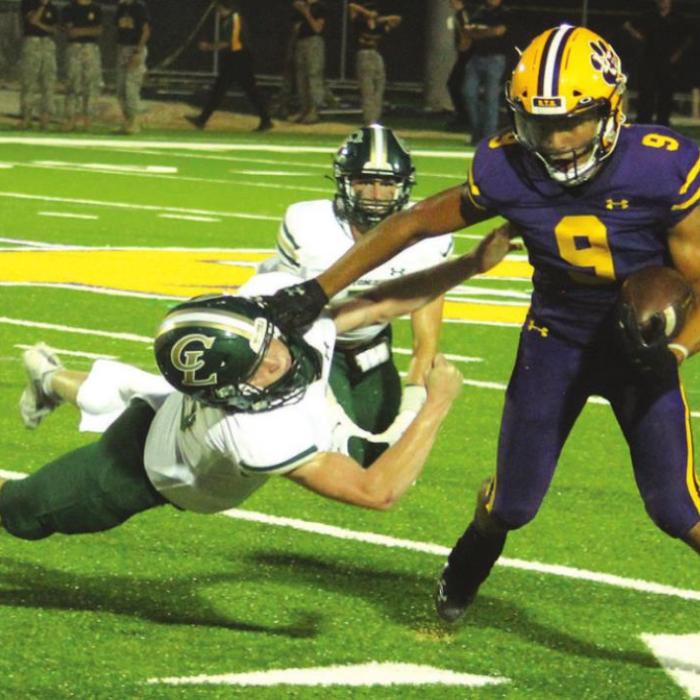 La Grange’s Jakobe Wilkerson pushes off a would-be tackler from Canyon Lake in Friday’s game. Photo by Jeff Wick