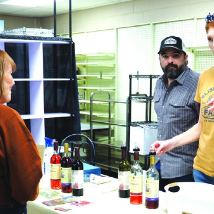 The 12th annual La Grange Uncorked wine festival was held Saturday in downtown La Grange as numerous Texas wineries were set up all around the courthouse square in businesses. Here Anthony and Melanie Lira extoll the virtues of various Rohan Meadery beverages to attendee Leigh Ann Bedient. Photo by Bobby Bedient