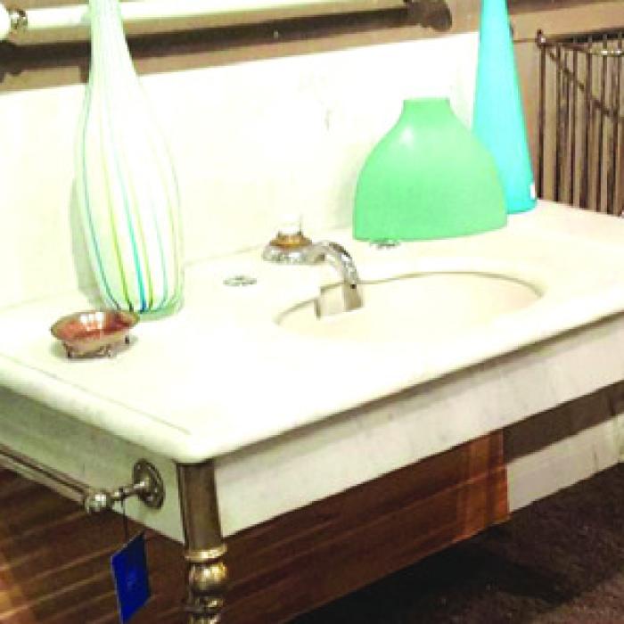 Marble sink with fancy legs, skirt, and backsplash, typical of the 1880s.