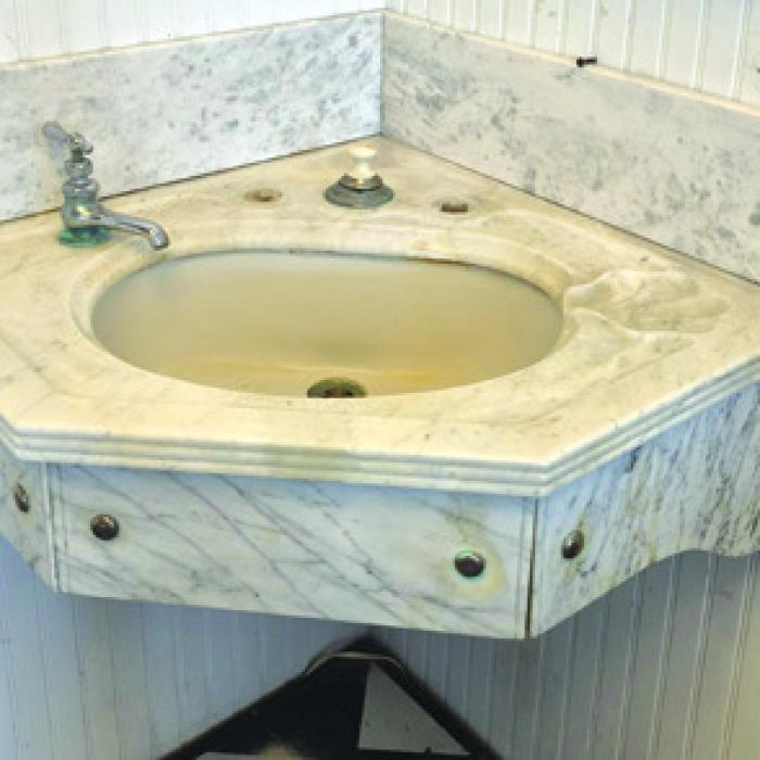 Corner marble sink. Skirt was custom made for modern installation.
