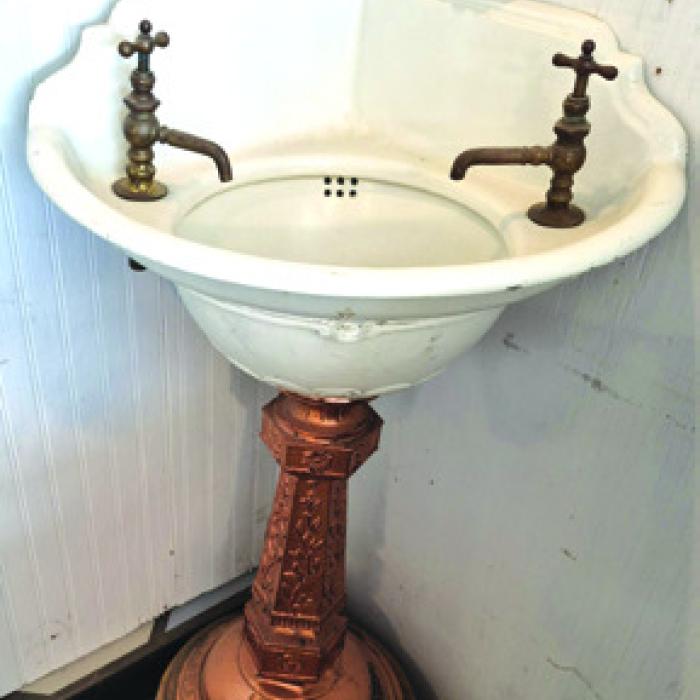 Fancy pedestal sinks like this date from the late 1870s and are hard to find. Note that people were a lot shorter then, so someone made the wooden plinth to raise the height. They also copper plated the pedestal.