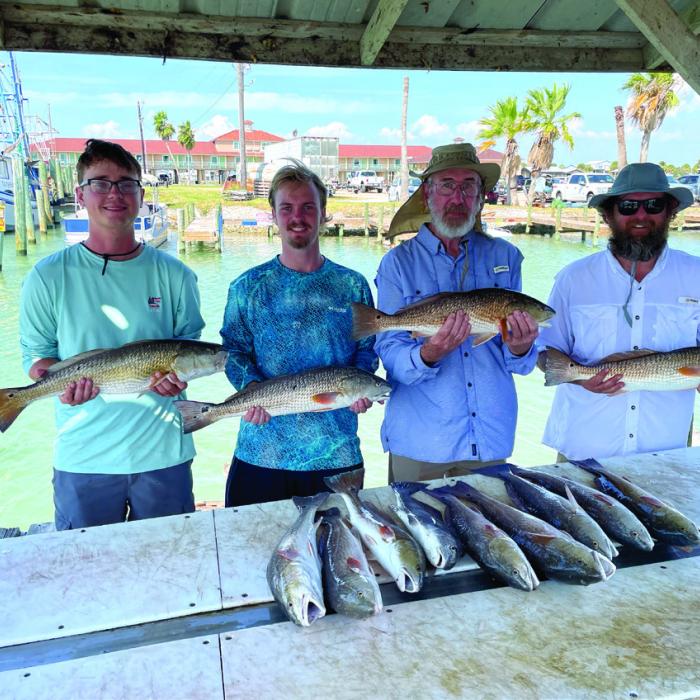 From left, my sons Sam and John with my dad, Kenneth Behlen, and myself after our recent fishing trip in Port O’Connor.