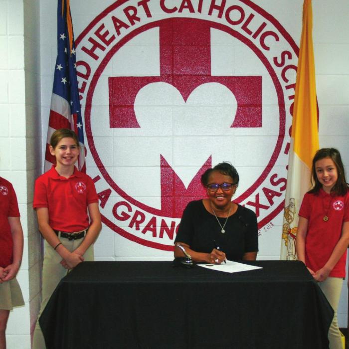 La Grange Mayor Jan Dockery signs Catholic Schools Week Proclamation. The theme for 2022 is “Catholic Schools: Faith. Excellence. Service.” Also pictured are Sacred Heart students, left to right: Cade Harbers, Fallon Wallace, Makenna Emmel, Mayor Jan Dockery, Leah Gulash, Leighton Peschke, Bowen Bishop. Staff photo by Amanda Gifford