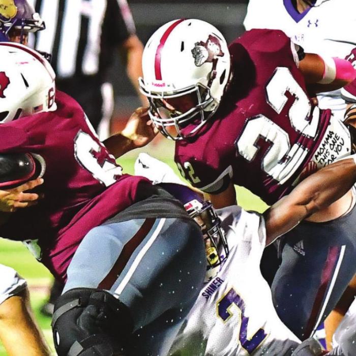 Aiden Gonzales (#22) carries for The Bulldogs while Kobe Burton (#60) and Ezequiel Rodrigues (#50) slow down Shiner defense. Photo by Stephanie Steinhauser