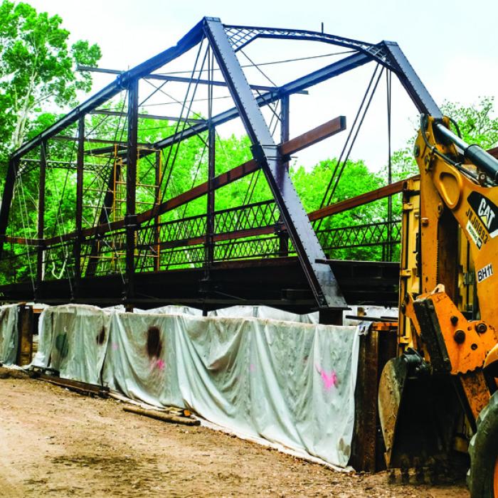 In this photo from April of 2025, the Willow Springs Bridge sits on the south bank of Cummins Creek while contractors build new concrete approaches. Then-Pct. 2 Commissioner Luke Sternadel said it took a 100-ton crane to pick up and move the bridge. The bridge itself does not weigh that much, but it took such a large piece of machinery due to the tricky nature of navigating the creek-bottom terrain. Record file photo by Andy Behlen