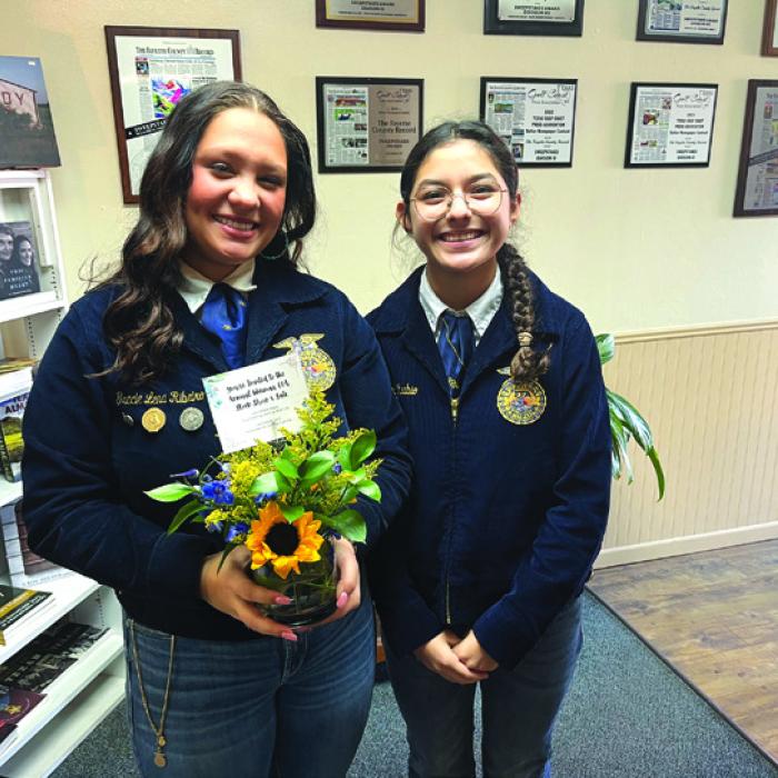 Weimer High School students Gracie Ribeiro, left, and Kimberly Rubio, right, stopped by The Fayette County Record newspaper office Friday to drop off a flower arrangement they made in their floral design class at school and to remind folks about the annual Weimar FFA Stock Show Friday Feb. 14 beginning at 8 a.m. and the sale the following day, Feb. 15 at 2:30 p.m.