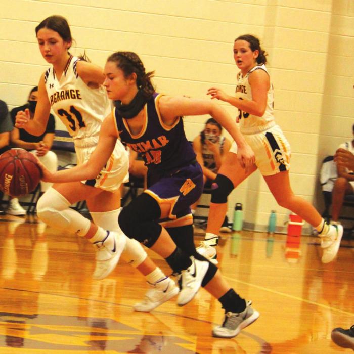 Weimar’s Kim Hinze drives down the court as left to right, La Grange’s, Keslyn Davis, Megan Brothers and Lyric Sampson pursue.