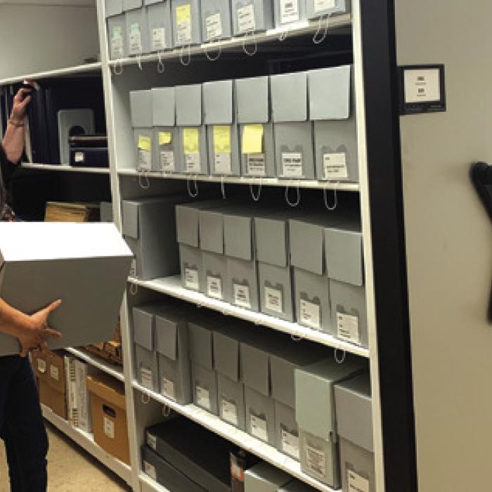 Archivists Rox Ann Johnson and Maria Rocha (front) organizing the new shelving.