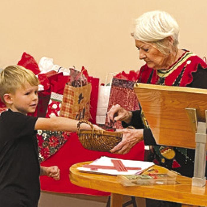 Dominik Woodworth selecting who is next to choose a White Elephant gift with Betty Danner.