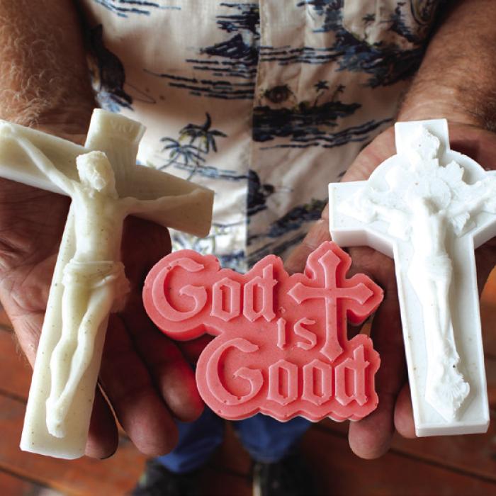 Doug Janda holds a trio of items made from the powdered marble of the old altar at the Queen of the Holy Rosary Church, which was destroyed by fire on June 9, 2022. Photo by Jessica Montez
