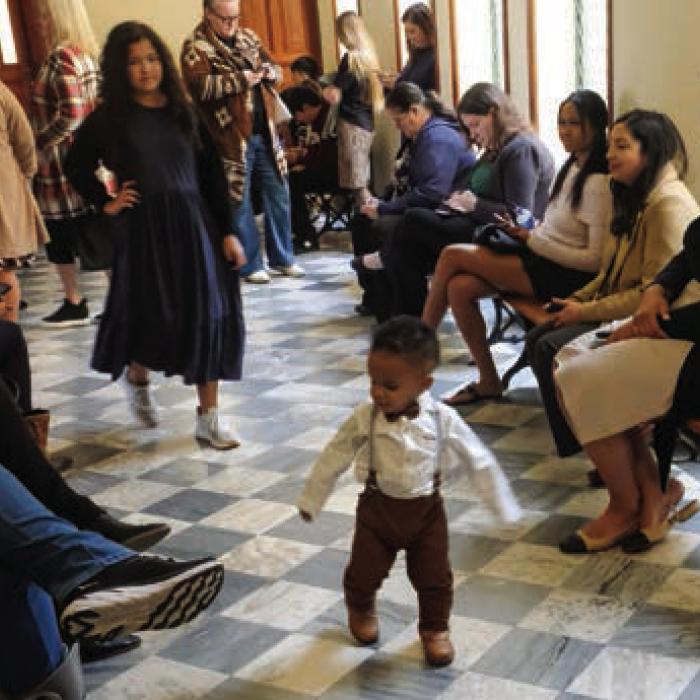 Little Jaxon Evans runs around the crowded hallway outside the district courtroom last Tuesday before his official adoption. Photo by Andy Behlen