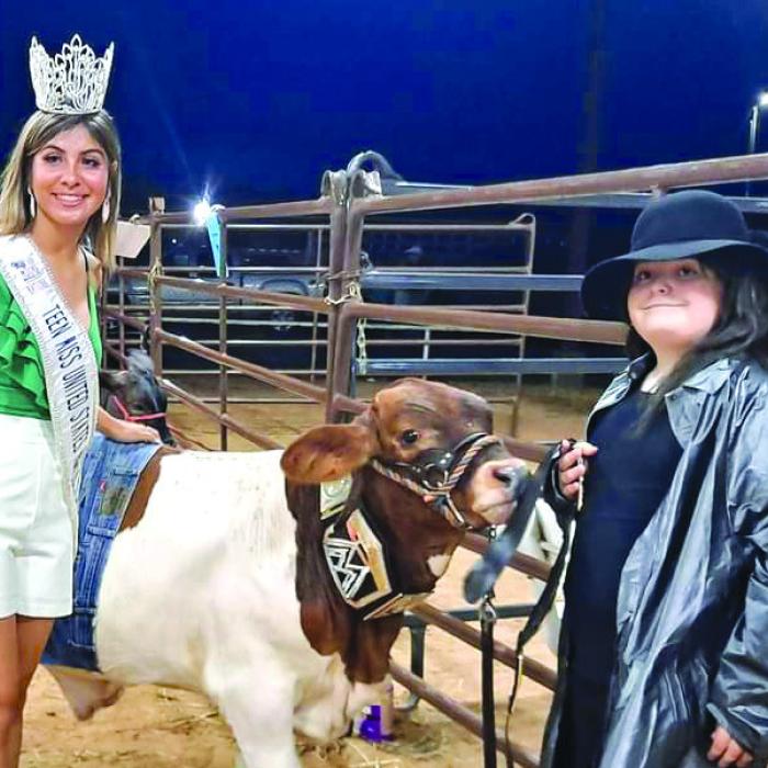 Kaylee Trejo, Miss Teen US Agriculture stopped for a picture with Rilan Karisch, dressed as The Undertaker and his beefmaster cross steer dressed as John Cena part of a costume contest at the fair.