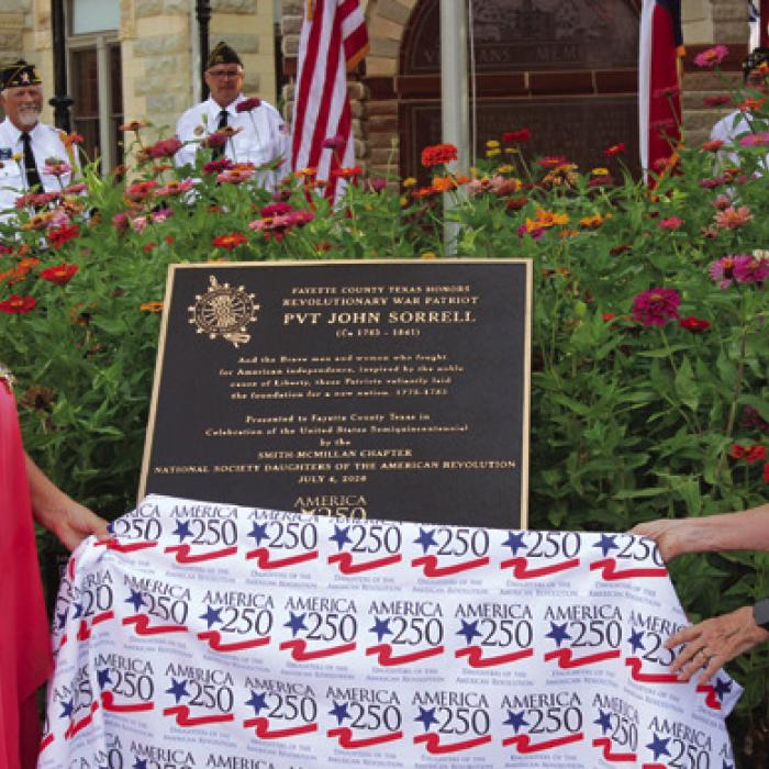 Gina Minzenmeyer, left, and Carolyn Caflisch, right, officially unveil the marker Saturday. Photo by Jeff Wick