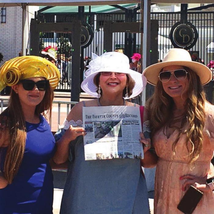 Kara Uhl, Jessica Montez and Madison Krenek took a moment from watching the Derby to read The Fayette County Record.