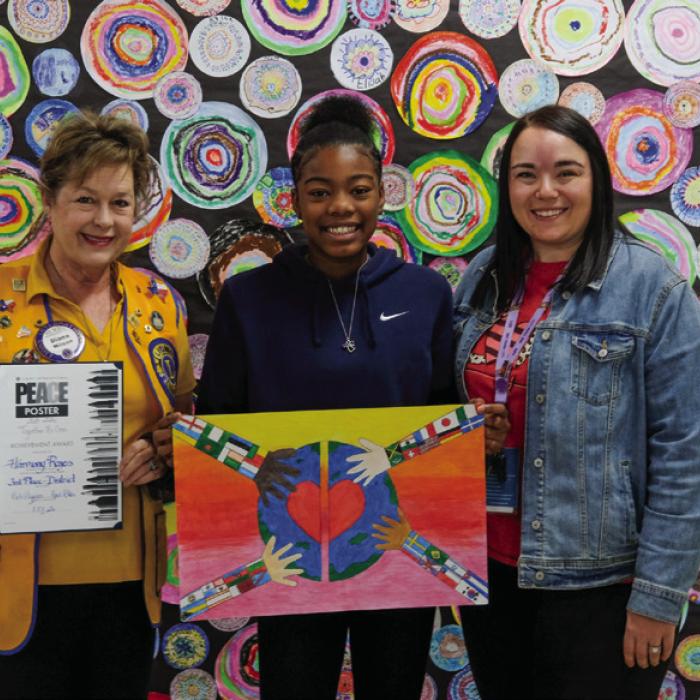 Harmony Rogers (center) of La Grange Elementary School won third place at the district level of the Lions International Peace Poster Contest. She is pictured here with her artwork alongside Diana Wilson of the La Grange Noon Lions (left) and La Grange Elementary Art Teacher Brittni Keilers. Photo by Andy Behlen