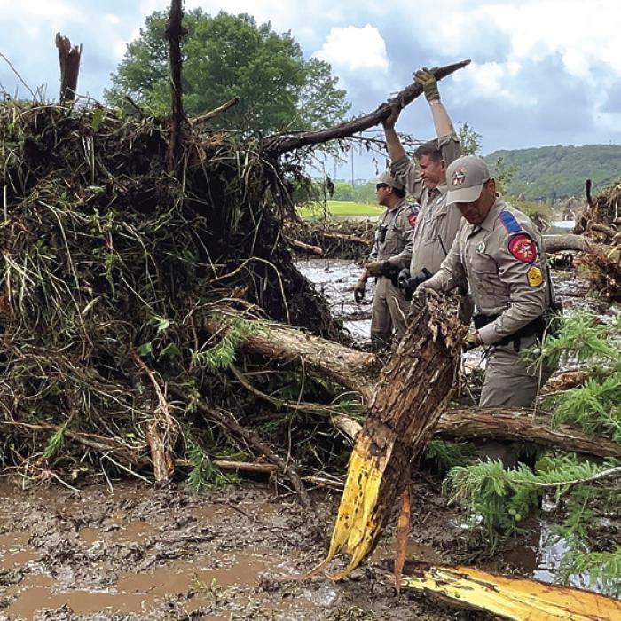 In this photo courtesy of the Texas Department of Public Safety, officers work to clear some of the massive debris fields from the July 4 storm in Kerr County.