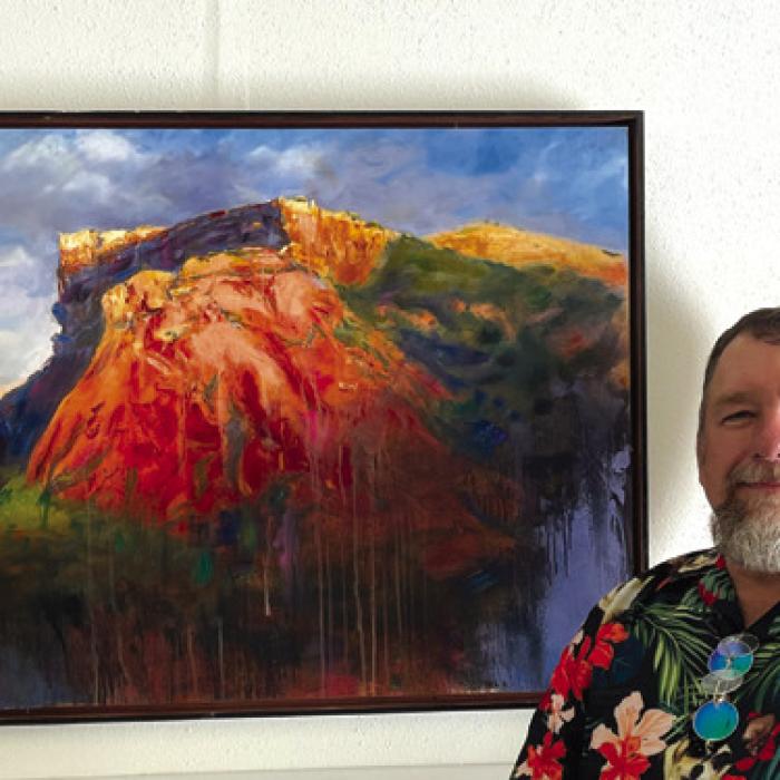Stephen Henry poses with his piece, “Sunrise on Caprock,” after winning the Alisa Rowe Award of Excellence.